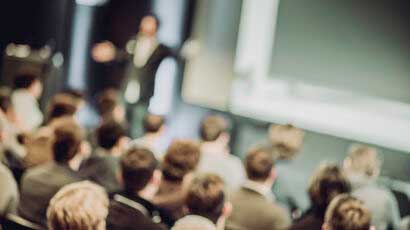 Blurred auditorium with speaker and audience
