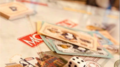 Different types of board games and cards and a dice on the table.