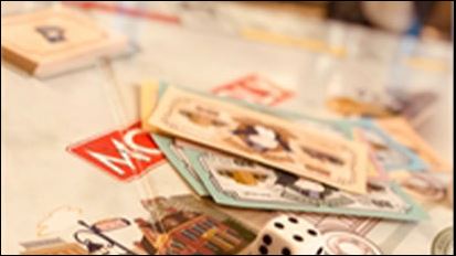 Different types of board games and cards and a dice on the table.