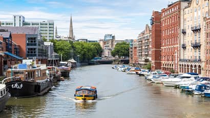 River scene with lots of boats and houses on both sides of the river in the heart of Bristol city centre. 