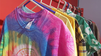 Colourful and vibrant shirts and t-shirts hanged on hangers.
