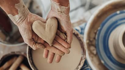 A heart shape clay on human hands
