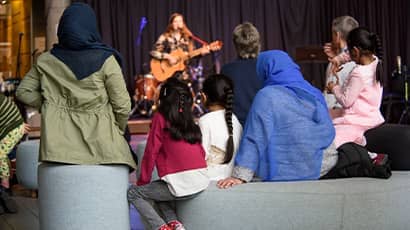 Family watching a singer perform.