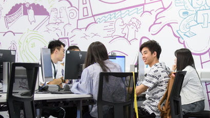 International students sat in a group working on computers