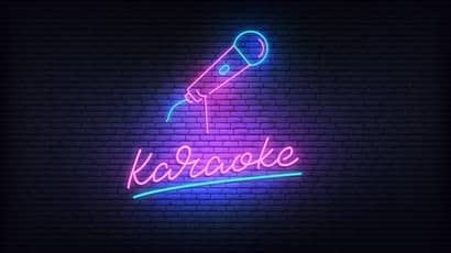 A neon mic and karaoke on a dark background