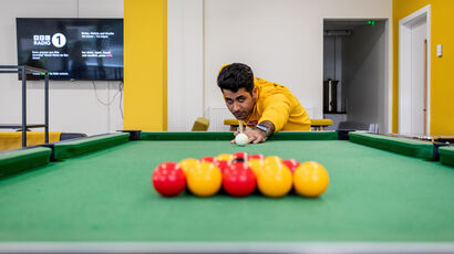A student playing pool.