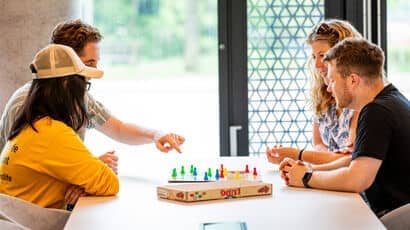 Four students chilling in Purdown View accommodation and playing board games
