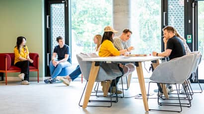 Lots of students socialising in student area. 