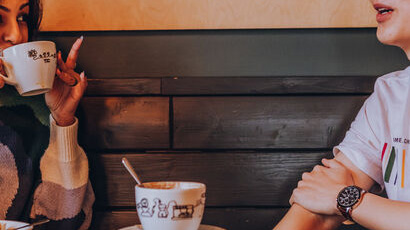 Two students drinking coffee and chatting.