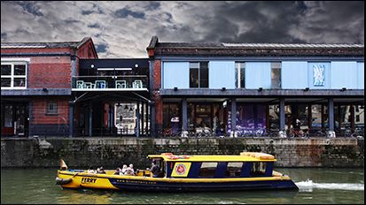 A scene of boat on a river and pubs near Bristol harbourside. 