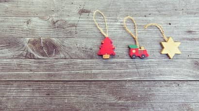 Three wooden decorations in shapes of Christmas tree, train and hexagon star.