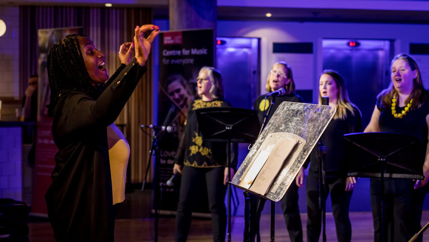 Choir signing together in unison at the Bristol Beacon.