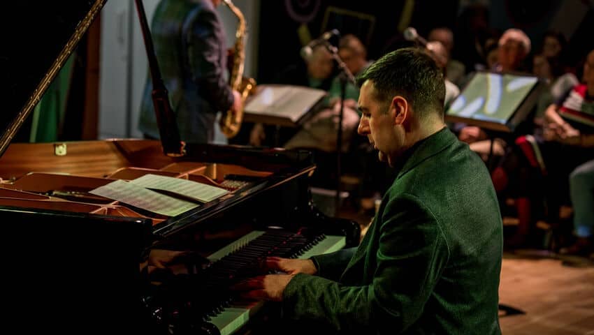 Pianist and saxophonists performing together on stage at the Bristol Beacon.
