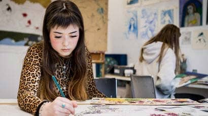 Student in a studio working on a piece of art.