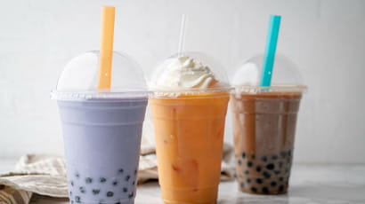 Three colourful bubble teas lined up in a row.
