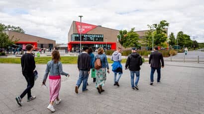 Group of people on a tour of Frenchay Campus walking by the Students' Union building.