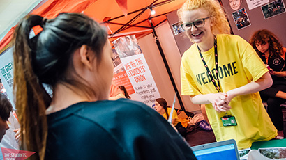 Student being welcomed by staff member at UWE Bristol Freshers' Fair 