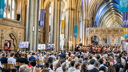 Crowd at Bristol Cathedral watching a graduation ceremony