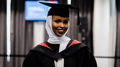 Graduate smiling dressed in cap and gown