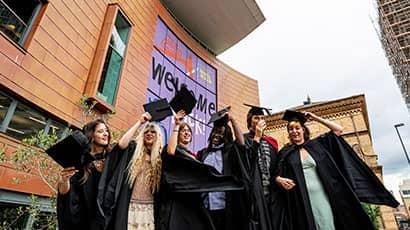 Before graduation - a group of graduates standing in front of the Bristol Beacon.