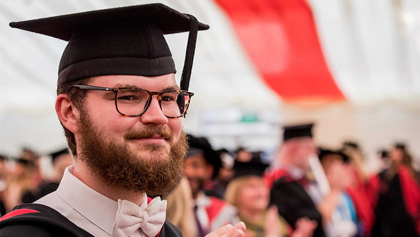 Close up of graduate in the marquee after the graduation ceremony