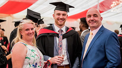 Graduate celebrating with family in the marquee
