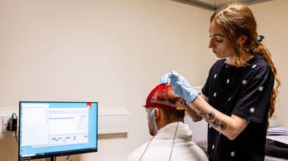 A psychology student preparing equipment for a patient assessment in the psychology lab.