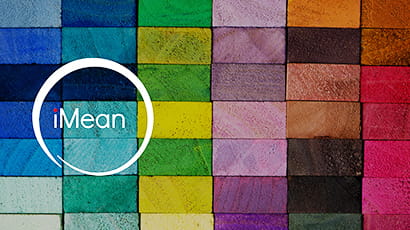 iMean conference logo on the left side over tightly arranged multi-coloured bricks.