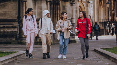 Four international students walking by Bristol Cathedral