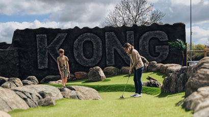 Two people playing adventure golf.