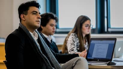 A group of law students listening to a lecture and taking notes.