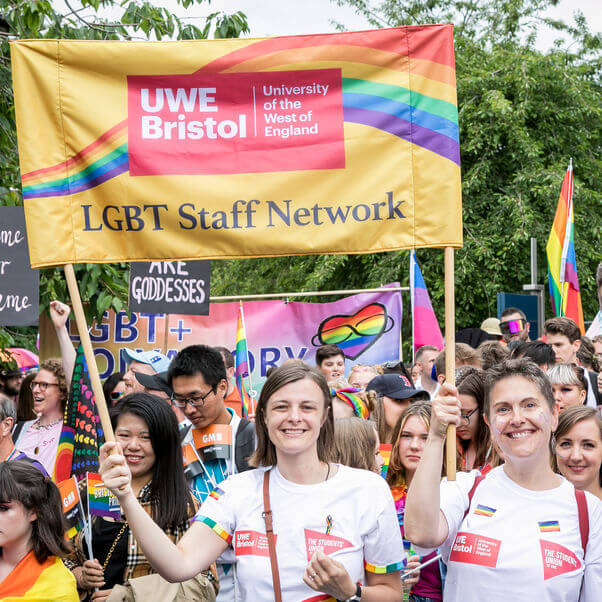 Group of people walking at LGBT Pride 2019 event, holding UWE Bristol LGBT Staff Network banner.