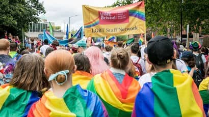 Group of people at Pride parade, holding UWE Bristol LGBT Staff Network banner.