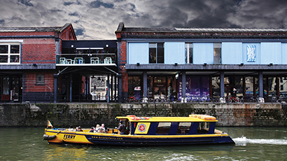 Front shot of Watershed building with a yellow boat sailing pass.