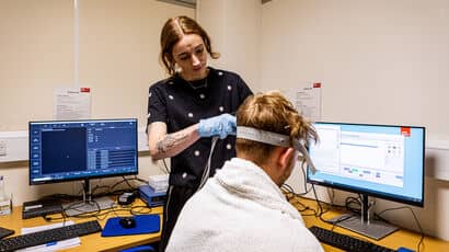 A psychology student preparing someone for an assessment in a lab.