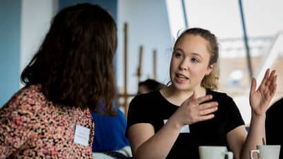 Two healthcare students talking to one another at a conference.