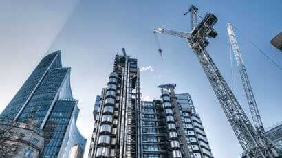 View looking up at a few skyscrapers and a crane
