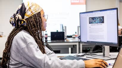 A student writing a scientific paper on a computer.