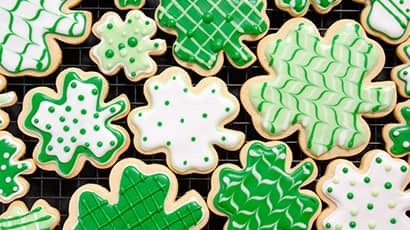 A selection of shamrock cookies decorated with green and white icing for St Patrick's Day.