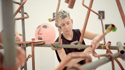 A student sets up their exhibition at a degree show