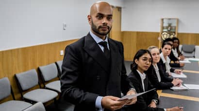 A group of trainee solicitors taking part in a simulation in a mock courtroom.