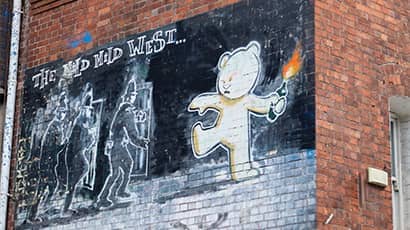 A photo of the Banksy work Mild, Mild West which depicts a teddy bear throwing a molotov at police.