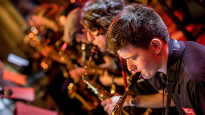 A group of musicians performing a concert with brass instruments.