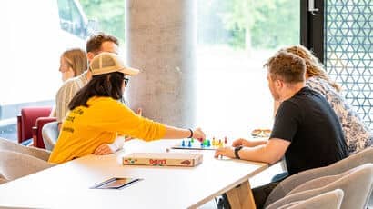 Student Life Ambassador playing a board game with students in Purdown View common room.