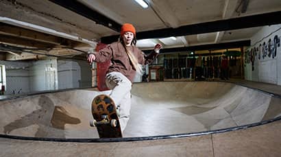 A woman on a skateboard at an indoor skatepark.