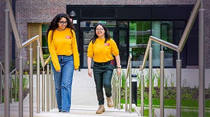 Two students in UWE Bristol sweatshirts walking up some steps