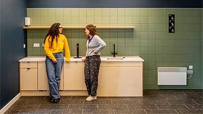 Two students chatting in a communal kitchen at Purdown View accommodation