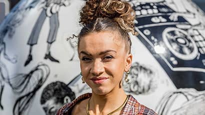 Alumni Jasmine Thompson in front of the globe she designed for Bower Ashton
