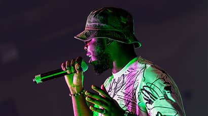 A Black man singing into a microphone