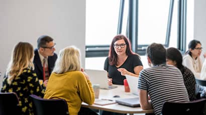 Continual Professional Development programme with people in discussion, sat around a table